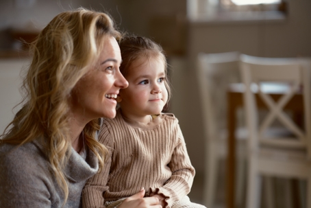 mother holding her daughter on her lap