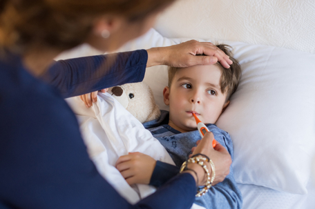 mother checking sick son's temperature