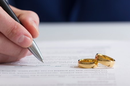 two wedding rings and divorce papers to symbolize divorce